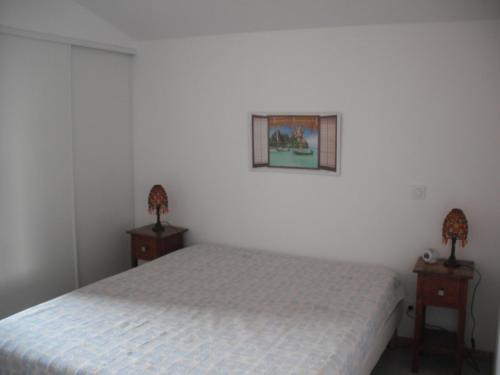 une chambre avec un lit et deux tables de nuit dans l'établissement Appartement Palm'Ares, à Arès