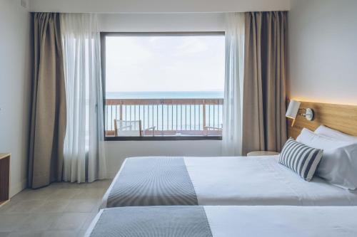 1 dormitorio con cama y ventana grande en AYA Seahotel - Adults Only, en Playa de Palma