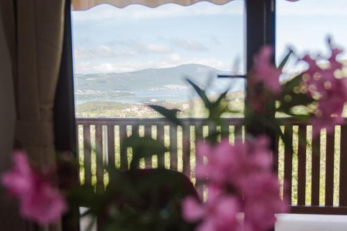 a view from a window with pink flowers in the foreground at Sunset Holiday Home in Tivat