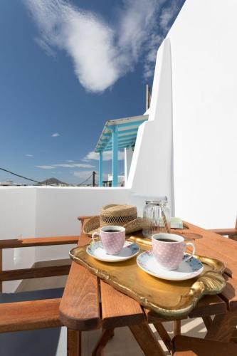 a wooden table with two coffee cups on it at Keti Kapri in Plaka