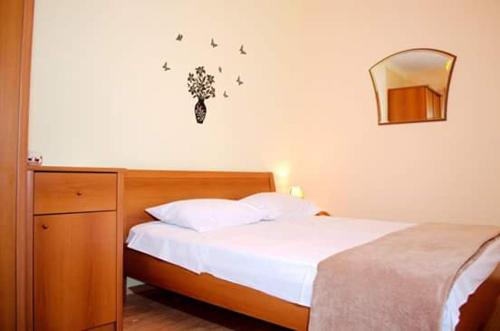 a bedroom with a bed and a mirror on the wall at Apartment Sunset in Trogir