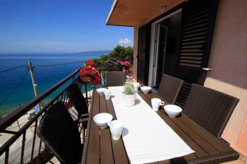 a balcony with a table and chairs and the ocean at Apartment Ana Bratus in Baška Voda