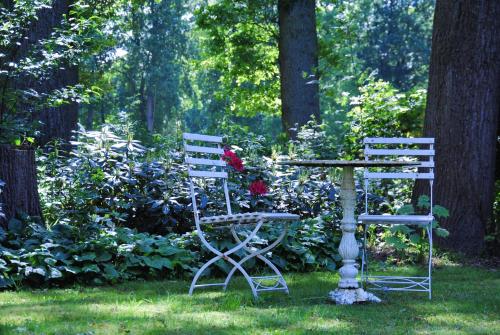 two chairs and a table in a garden at Landgoedhoeve Vosbergen in Heerde