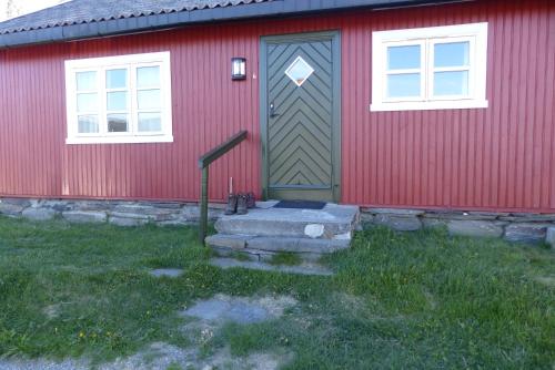 a house with a fire hydrant in front of a building at Skåbu Hytter og Camping in Skåbu