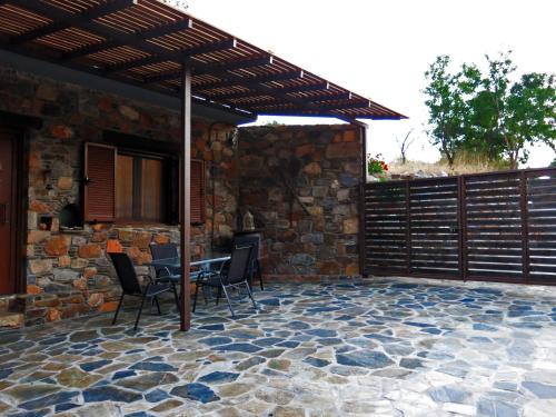 a patio with a table and chairs under a wooden pergola at "PefkoPetro" Traditional House in Keramotí