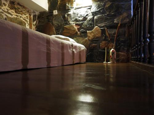 a room with a bed and a dog next to a stone wall at "PefkoPetro" Traditional House in Keramotí