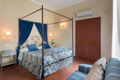 a bedroom with a canopy bed with blue pillows at Leon Bianco in San Gimignano