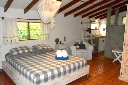 Un dormitorio con una cama con dos zapatos. en Beso del Viento (Adults Only), en Parrita