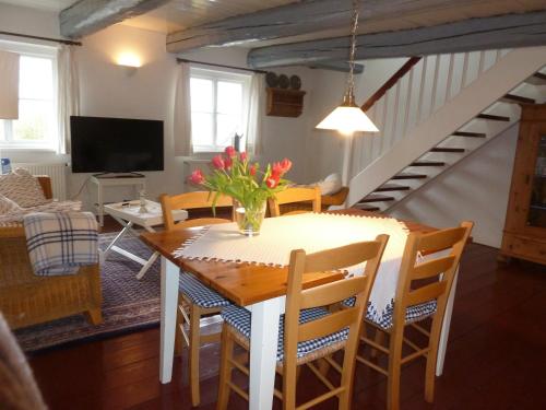 a dining room and living room with a table and chairs at Hof Homfeld in Ditzum