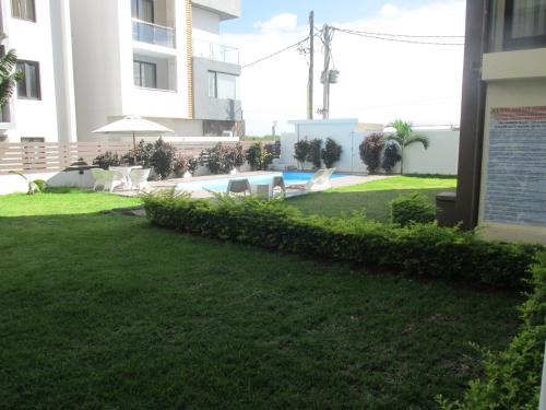 a yard with a swimming pool in a building at Mahina Luxury 2 Bedroom Apartment with Pool in Flic-en-Flac