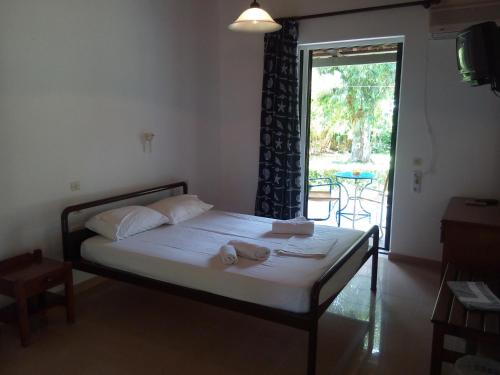 Hotel Dougas في أركودي: غرفة نوم عليها سرير وفوط