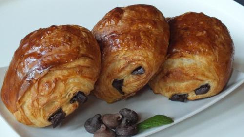 three croissants on a white plate on a table at Historic District BnB in Saint Paul