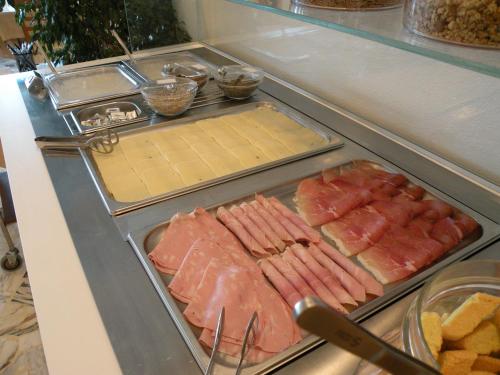 a refrigerator filled with lots of meats and cheese at Hotel Parrini in Follonica