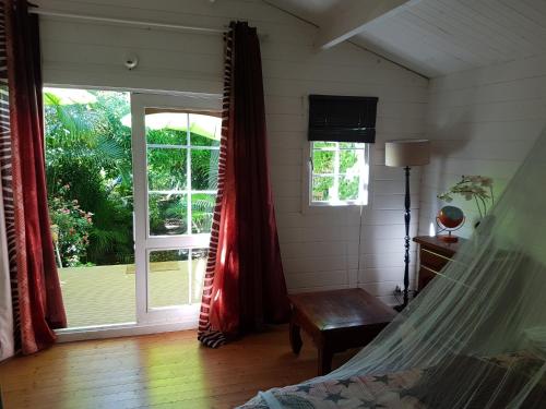 a room with a hammock and a sliding glass door at Bungalow meublé près du lagon in La Saline les Bains