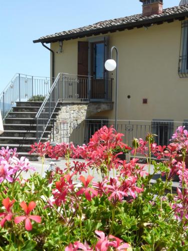 a garden with pink flowers in front of a house at Podere Del Griccia in Civitella in Val di Chiana