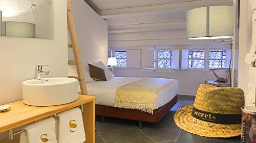 Habitación con baño con cama y lavabo. en Hotel Secrets Priorat en Falset