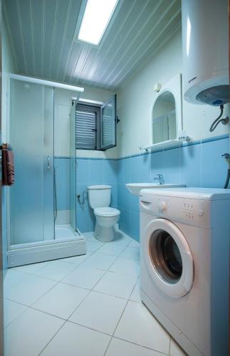 a bathroom with a washing machine and a toilet at Dobrljanin LUX apartment in Budva