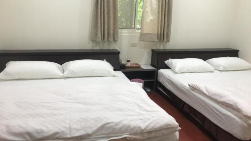 two beds in a room with white sheets and pillows at SuWaNa in Leye