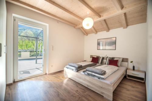 - une chambre avec un grand lit et une grande fenêtre dans l'établissement Hermann Gatscher, à Bolzano