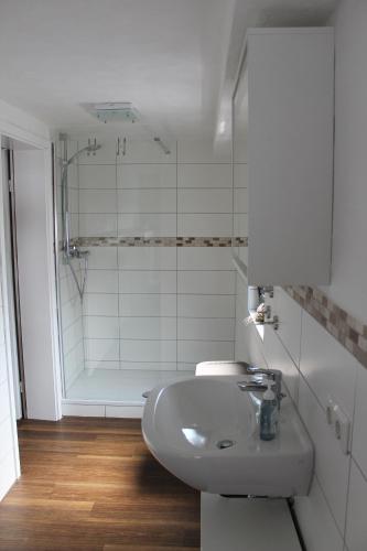 a white bathroom with a sink and a shower at Casa Metzjersch in Gemünden