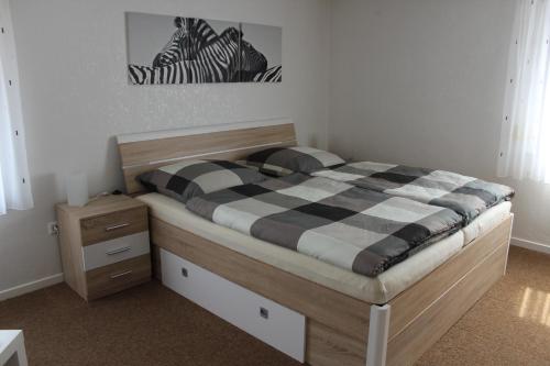 a bedroom with a bed with a black and white checkered blanket at Casa Metzjersch in Gemünden