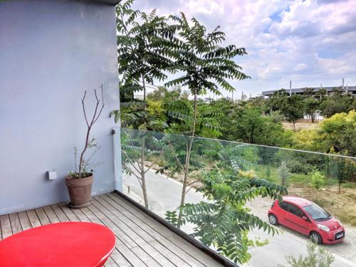 a balcony with a red table and a red car on a balcony at Verde Apartments in Athens