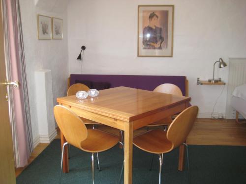 una mesa de comedor con 4 sillas alrededor en Farmer Annekset Ravning, en Bredsten
