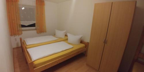 een kleine slaapkamer met 2 bedden en een raam bij Ferienwohnung Belisa in Burgau