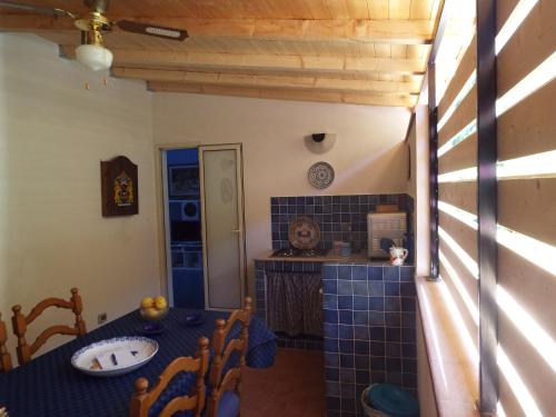 カステッランマーレ・デル・ゴルフォにあるLe Case di VirGin 2のキッチン(テーブル、青いタイル張りのカウンター付)