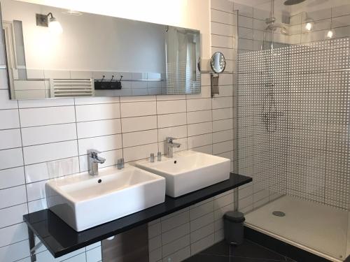 a bathroom with two sinks and a shower at La Rapière in Carcassonne