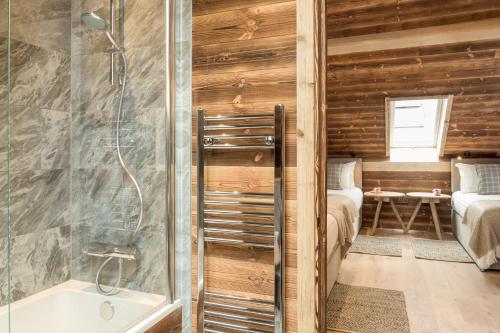a bathroom with a shower and a tub and a bedroom at Cairngorm Lodge in Aviemore