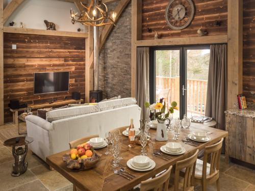 a living room with a table and a couch at Cairngorm Lodge in Aviemore