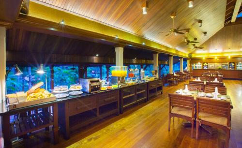 een restaurant met een aquarium in het midden van een kamer bij Khaolak Bayfront Resort in Khao Lak