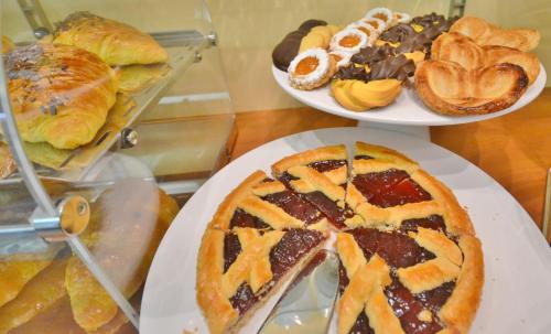 a table with two plates of pastries and other desserts at Gold Hotel in Bordighera