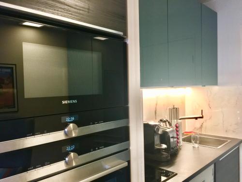 La cuisine est équipée de placards verts et d'un four micro-ondes. dans l'établissement Cannes Pool & Beach, à Cannes