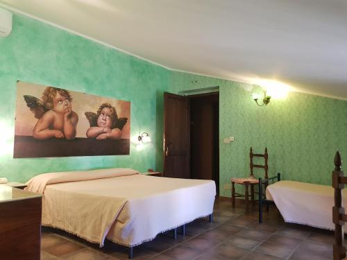 a bedroom with two beds in a green wall at Casale Villa Rainò in Gangi