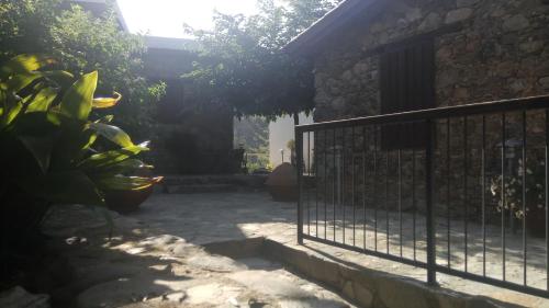 a fence in front of a house with plants at Enipnion Apartments in Kakopetria