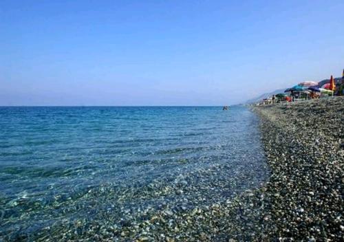 a beach with a rocky shore and the ocean at La Casa della Filanda in Belmonte Calabro