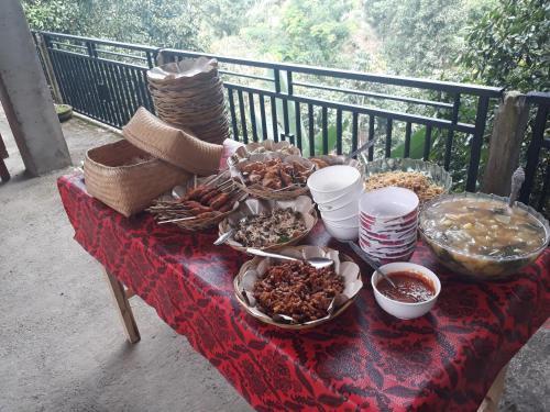 a table topped with bowls of food on a balcony at Sugi Gede Homestay in Singaraja