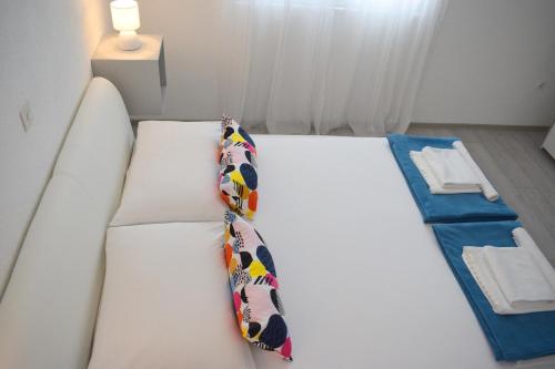 a bed in a room with a tie on it at Apartments Milas in Trogir