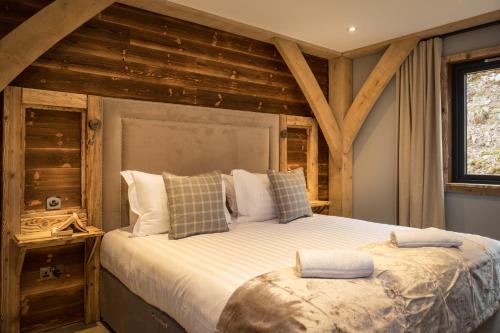 アビモアにあるMacdui Lodgeの木製の壁のベッドルーム1室(大型ベッド1台付)