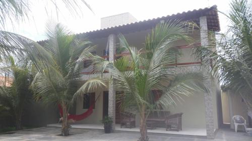 a building with palm trees in front of it at Batista's Beach in Luis Correia