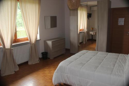 a bedroom with a large white bed and windows at lavillaparking in Borgaro Torinese
