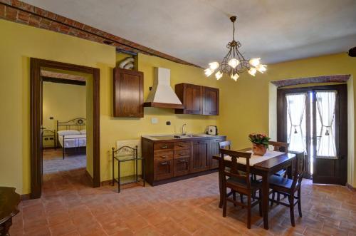 a kitchen with a table and a dining room at Palazzo Centro Alloggi Vacanza in Nizza Monferrato