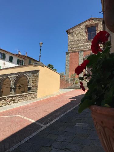 a vase with a flower in front of a building at Casa Vacanza Lucignano in Lucignano