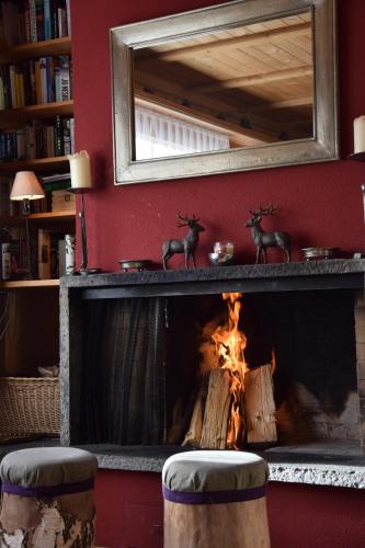 a fireplace in a living room with a fire at Chalet Im Wieselti in Langwies