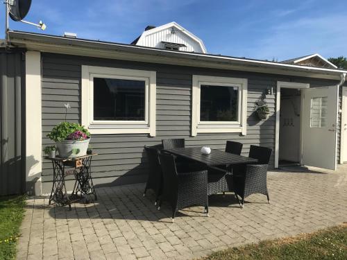 un patio con mesa y sillas frente a una casa en Gårdshus i Borgholm, Öland, en Borgholm