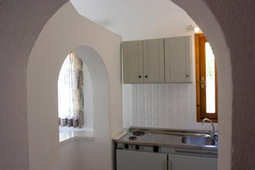 eine Küche mit einem Waschbecken, einem Fenster und einer Theke in der Unterkunft Olga Suites in Maleme