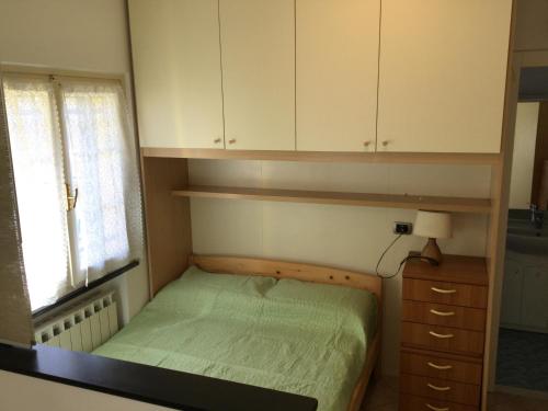 a small bedroom with a bed and a cabinet at La casetta della nonna in Sestri Levante