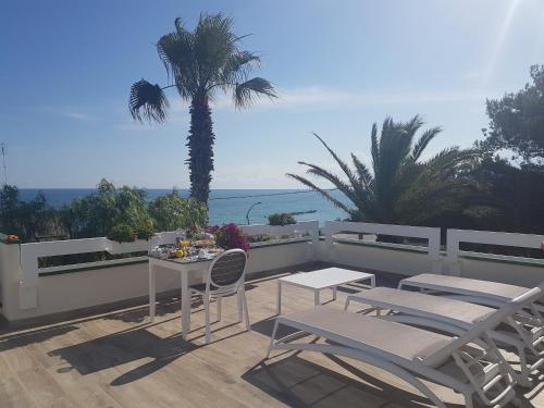 a patio with a table and chairs and a palm tree at B&B TORRE AZUL FRONTEMARE - Bisceglie in Bisceglie